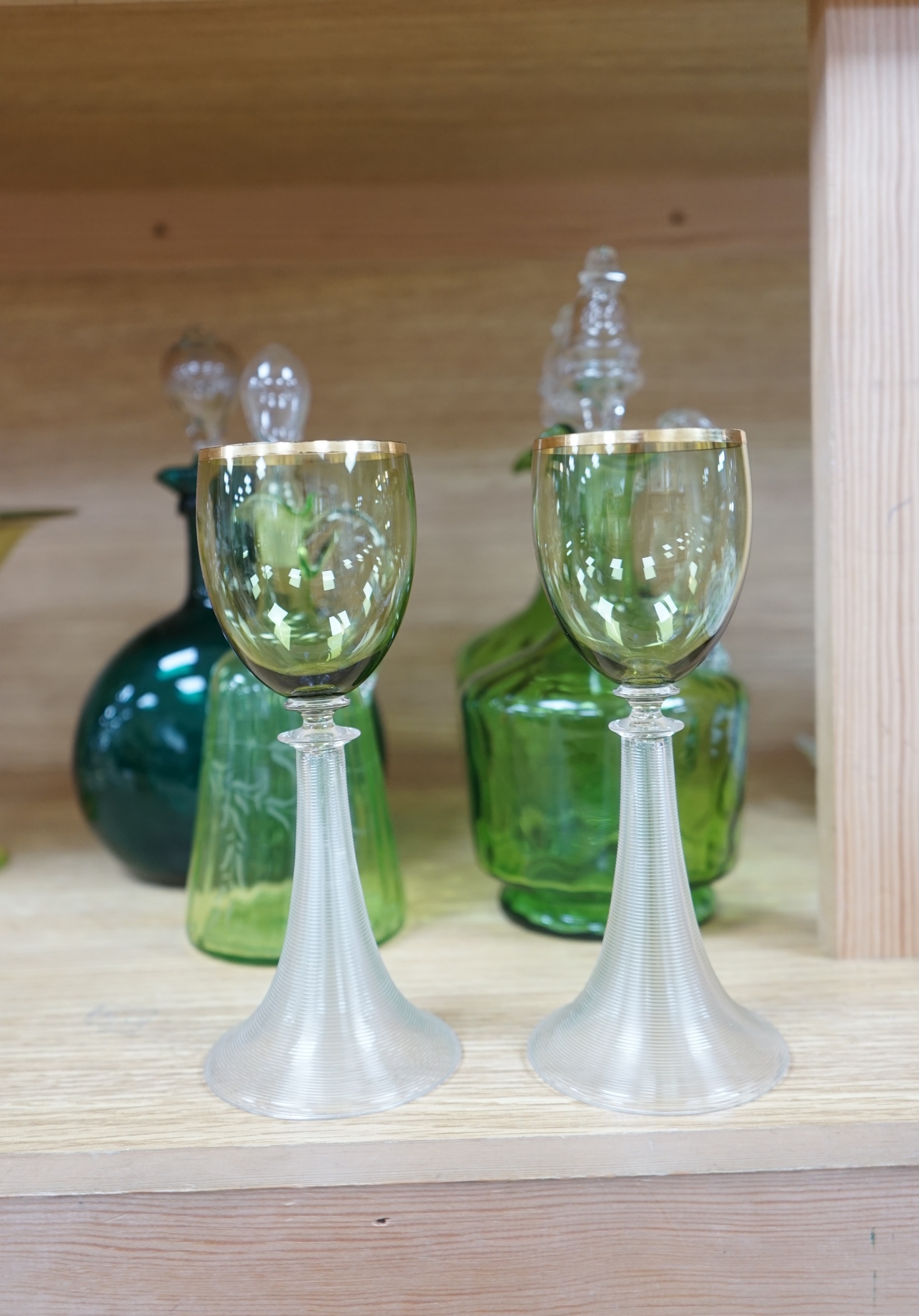 Ten glass items; a pair of green hock glasses, six liqueur decanters, a pedestal table centre and a mug. Condition - good.